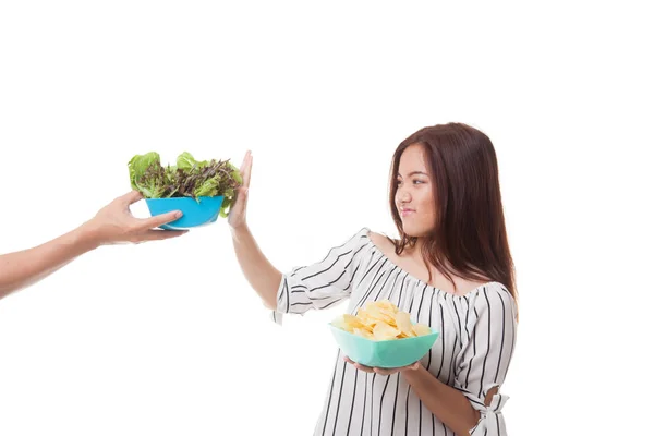 Jonge Aziatische vrouw met aardappel chips nee zeggen tegen salade. — Stockfoto