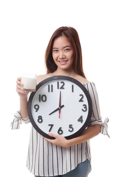 Gezonde Aziatische vrouw drinkglas van melk houd clock. — Stockfoto