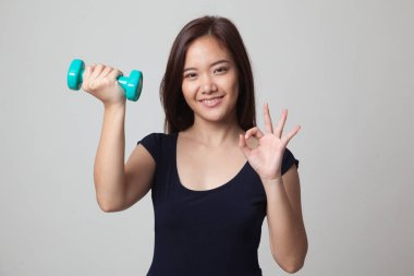 Sağlıklı Asyalı kadın gösteri Tamam dumbbells ile.