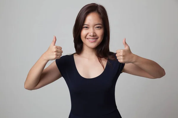 Jonge Aziatische vrouw Toon tweetal duimschroef opwaarts. — Stockfoto
