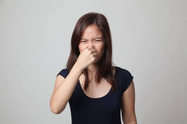 Jonge Aziatische vrouw met haar neus vanwege een slechte geur. — Stockfoto