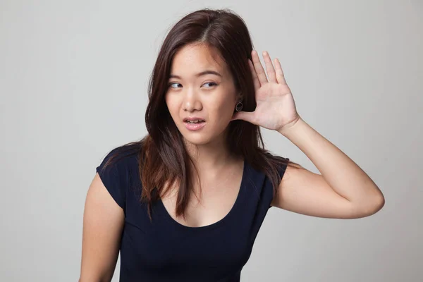 Gyönyörű fiatal ázsiai nő hallgatni valami. — Stock Fotó