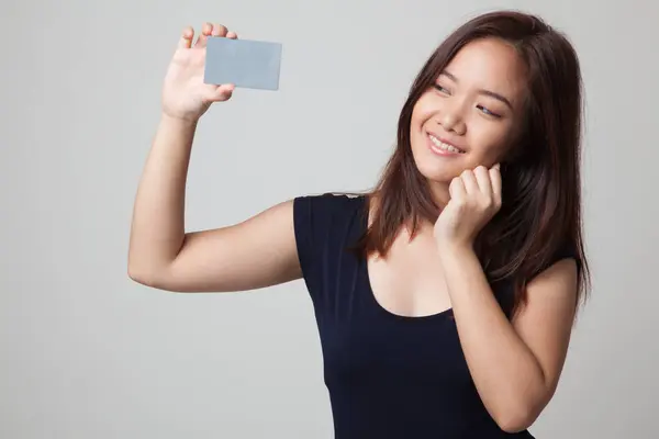 Feliz joven asiática mujer con una tarjeta en blanco . — Foto de Stock