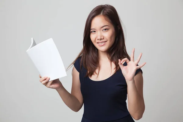 Jonge Aziatische vrouw show Ok met een boek. — Stockfoto