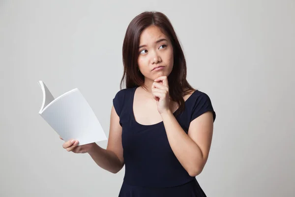 Jonge Aziatische vrouw met een boek is denken. — Stockfoto