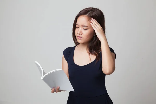 Genç Asyalı kadın baş ağrısı okuma kitabım. — Stok fotoğraf