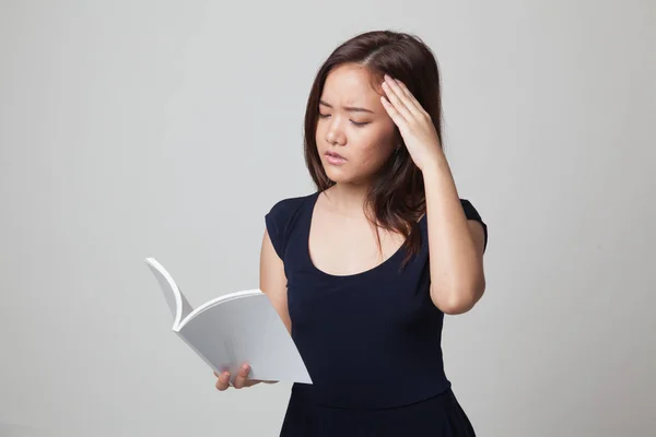 Giovane donna asiatica ha avuto mal di testa leggere un libro . — Foto Stock