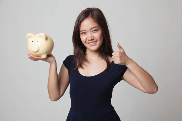 Asian woman thumbs up with pig coin bank. — Stock Photo, Image