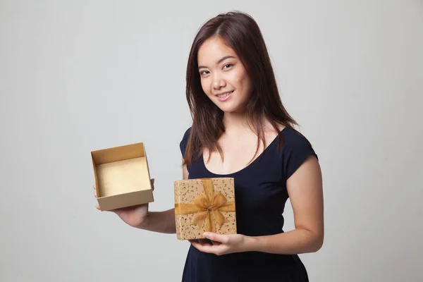若いアジア女性が黄金のギフト ボックスを開く. — ストック写真