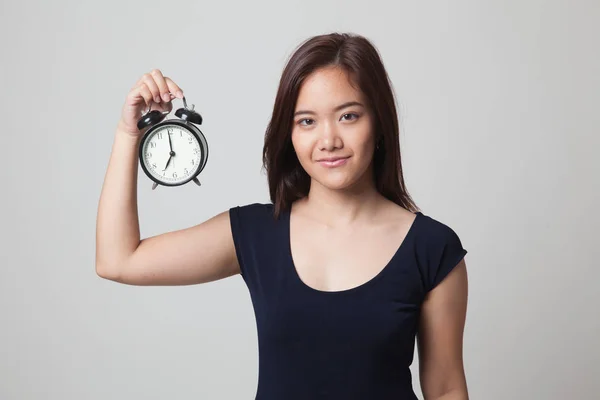 Young Asian woman with a clock. — Stock Photo, Image