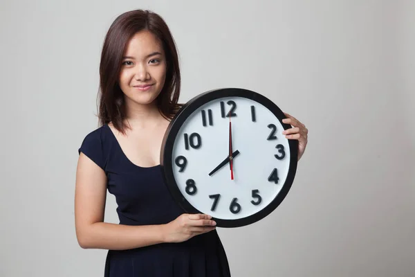 Jong aziatisch vrouw met een klok. — Stockfoto