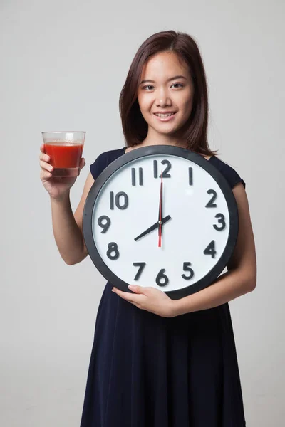 Jovem mulher asiática com suco de tomate e relógio . — Fotografia de Stock