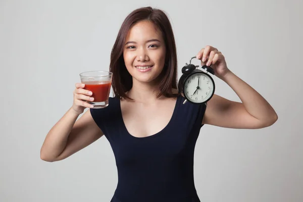 Jeune femme asiatique avec du jus de tomate et horloge . — Photo