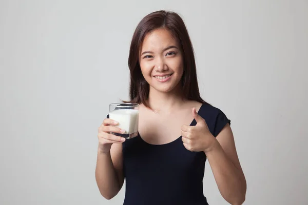 Saludable mujer asiática bebiendo un vaso de leche pulgares arriba . — Foto de Stock