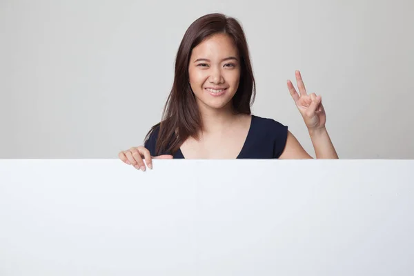 Jonge Aziatische vrouw overwinning teken met leeg teken weergeven. — Stockfoto