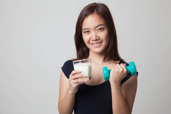 Gesunde asiatische Frau trinkt ein Glas Milch und Hantel. — Stockfoto