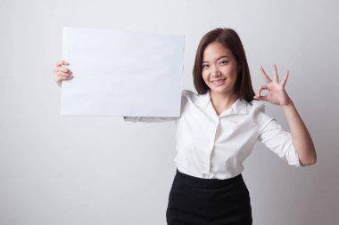 Genç Asyalı kadın göster Tamam beyaz boş işaretiyle.