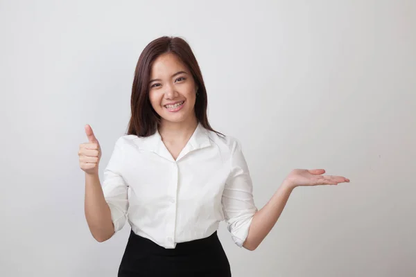 Schöne junge asiatische Frau zeigen Handfläche Hand und Daumen nach oben. — Stockfoto