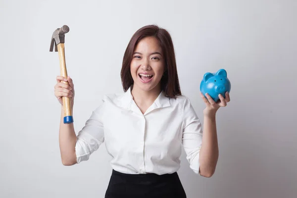 Aziatische vrouw met varken munt bank en hamer. — Stockfoto