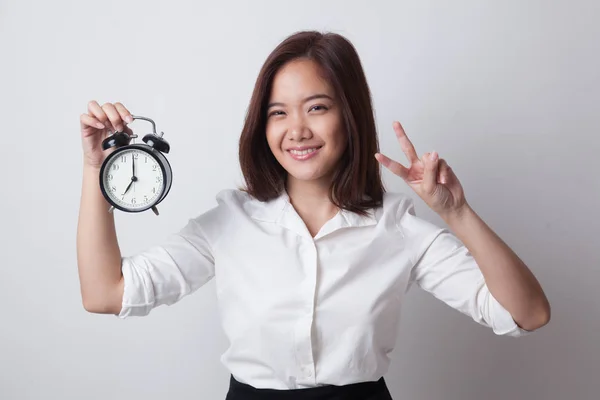 Junge asiatische Geschäftsfrau zeigen Siegeszeichen mit einer Uhr. — Stockfoto