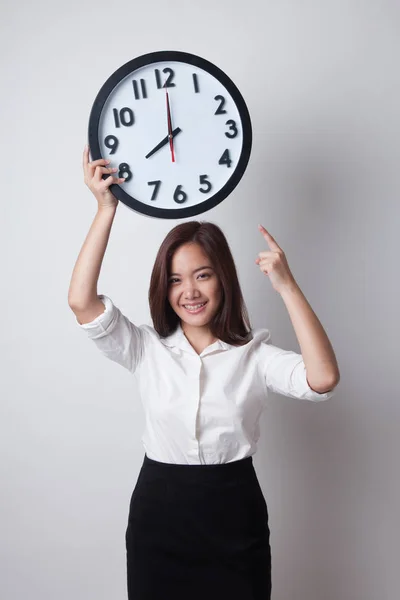 Junge asiatische Geschäftsfrau zeigen auf eine Uhr. — Stockfoto