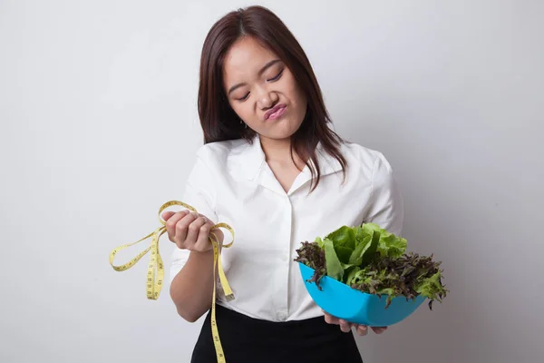 Olycklig asiatisk kvinna med mätning av tejp och sallad. — Stockfoto