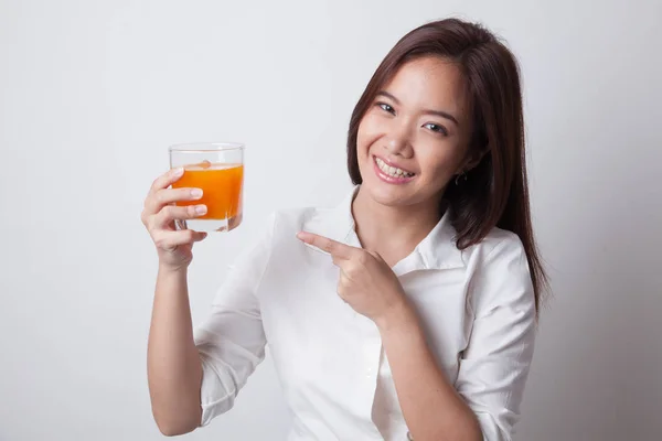 Junge Asiatin zeigt auf Orangensaft. — Stockfoto