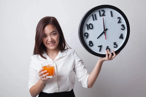 Femme asiatique avec une horloge boisson jus d'orange . — Photo