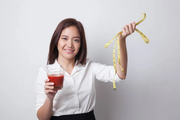 Mujer asiática con jugo de tomate y cinta métrica . — Foto de Stock