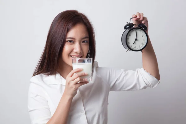 Friska asiatisk kvinna dricksglas mjölk håller klockan. — Stockfoto