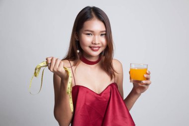 Asyalı kadın içki portakal suyu tutun teyp ölçme.