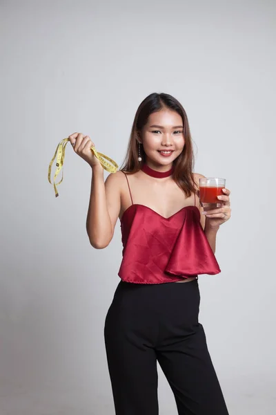 Mujer asiática con jugo de tomate y cinta métrica . —  Fotos de Stock