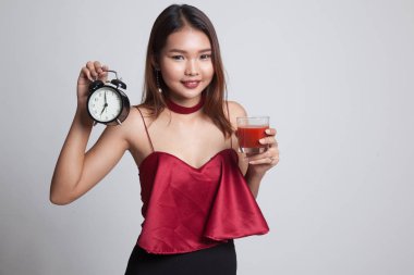 Domates suyu ve saat ile genç Asyalı kadın.