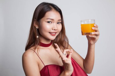 Genç Asyalı kadın gösteri Tamam portakal suyu içmek.