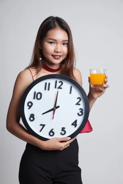Mujer asiática con un reloj beber jugo de naranja . —  Fotos de Stock