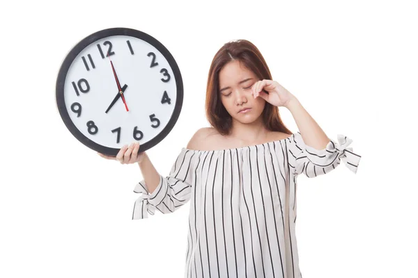 Schläfrige junge asiatische Frau mit einer Uhr am Morgen. — Stockfoto