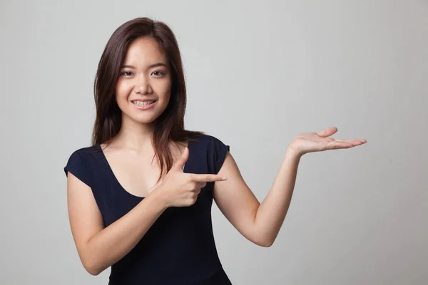 Beautiful young Asian woman point to palm hand. — Stock Photo, Image