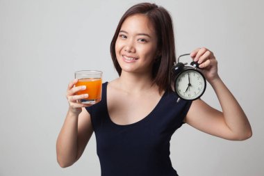 Asyalı kadın saati içki portakal suyu ile.