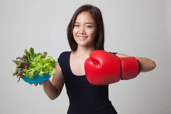 Joven mujer asiática con guante de boxeo y ensalada . — Foto de Stock