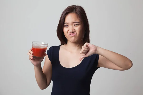 Asiatisk kvinna tummen ner hatar tomatjuice. — Stockfoto