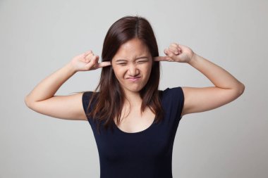 Genç Asyalı kadın parmakları ile her iki kulak engellemek.