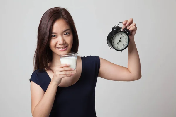 Gesunde asiatische Frau trinkt Glas Milch halten Uhr. — Stockfoto