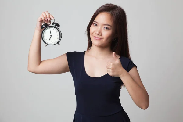 Junge asiatische Frau zeigen Daumen nach oben mit einer Uhr. — Stockfoto