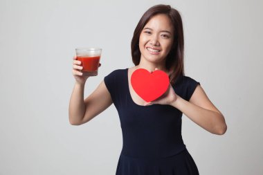 Domates suyu ve kırmızı kalpli genç Asyalı kadın.