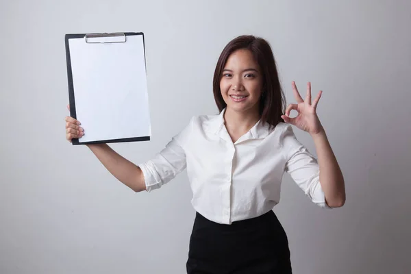 Junge asiatische Geschäftsfrau zeigen ok und blank Klemmbrett. — Stockfoto