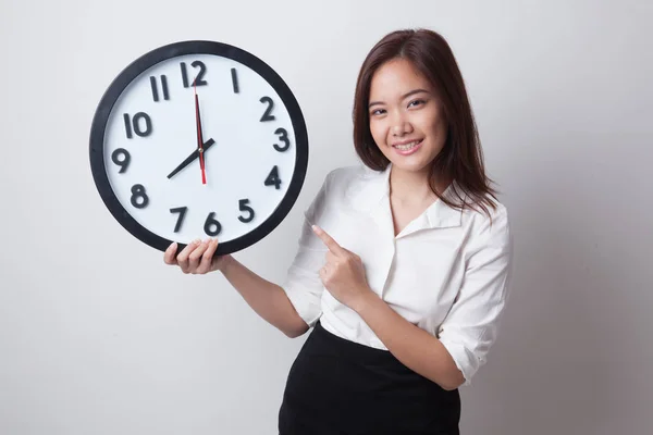 Ung asiatisk kvinna punkt till en klocka. — Stockfoto