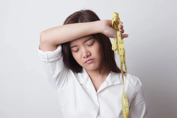 Ongelukkige jonge Aziatische vrouw met meetlint. — Stockfoto
