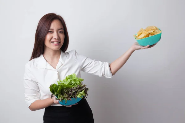 Jeune femme asiatique avec croustilles et salade . — Photo