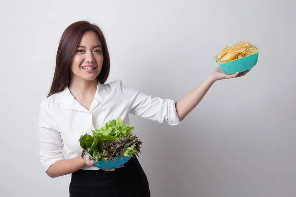 Ung asiatisk kvinna med potatischips och sallad. — Stockfoto