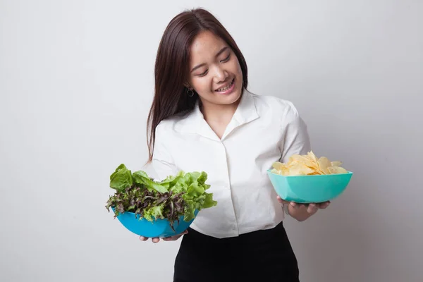 Jovem mulher asiática com batatas fritas e salada . — Fotografia de Stock